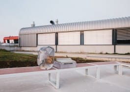 Soldering Equipment and a Laptop computer cast in epoxy resin in the form of a blob and a impact printer rest on a bench in front of a secondary engineering school 