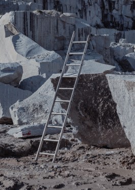 A ladder propped against a granite slab in a quarry