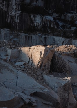 sunrays illuminating a granite rockface in a quarry