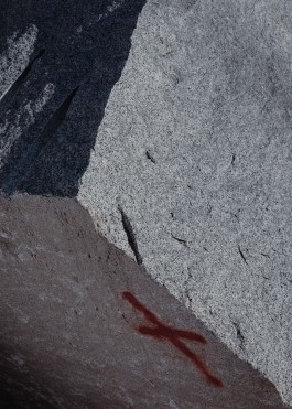 Close up of a granite slab marked with a red cross in a quarrry