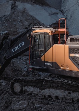 an volvo excavator partially illuminatd by the sun