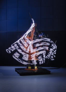 A long exposure of an industrial robot painting a distorted image onto the camera sensor.