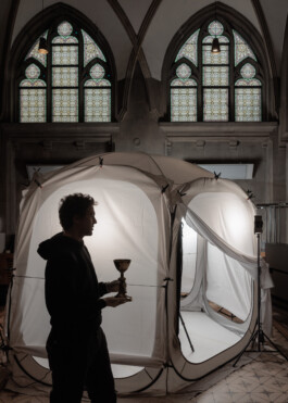 Digitization Expert Dominik Juchung seen in front of a light tent in a side hall of the Mariendom Cathedral in Linz. He is using diffuse light to create even shadows on golden artefacts in order to photograph them from all sides for a later 3D reconstruction of the artefact.