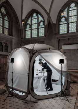 Digitization Expert Dominik Juchung seen in front of a light tent in a side hall of the Mariendom Cathedral in Linz. He is using diffuse light to create even shadows on golden artefacts in order to photograph them from all sides for a later 3D reconstruction of the artefact.