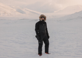 Full Body Shot of Florian Voggeneder dressed in black Arctic Gear in front of a snowy landscape